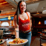 A server handing a guest an entree