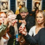 6 people posing with a shot cheersing