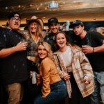 people posing for a picture with some alcohol in their hands