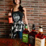 Waitress posing with bottles of Jack Daniels